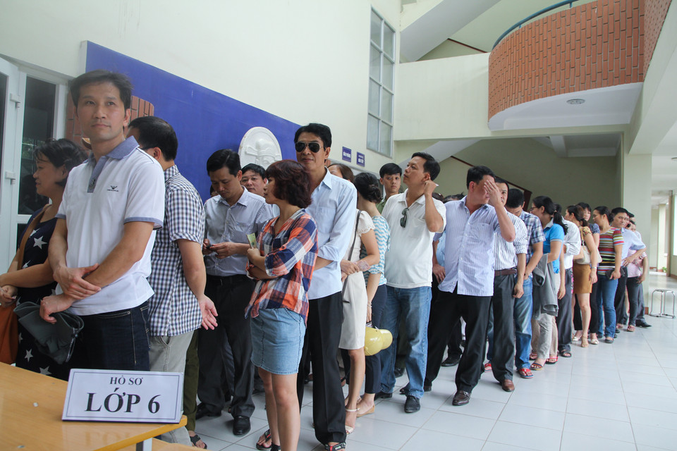 Phần lớn phụ huynh mua hồ sơ cho con em mình vào lớp 6. Nhiều phụ huynh vẫn tỏ ra khá thất vọng và lo lắng vì thông tin mà họ mong chờ nhất là trường sẽ xét tuyển theo các tiêu chí cụ thể nào, các tiêu chí đó được tính như thế nào để làm căn cứ xét tuyển vào trường thì vẫn chưa rõ ràng. (Ảnh: Minh Sơn/Vietnam+)