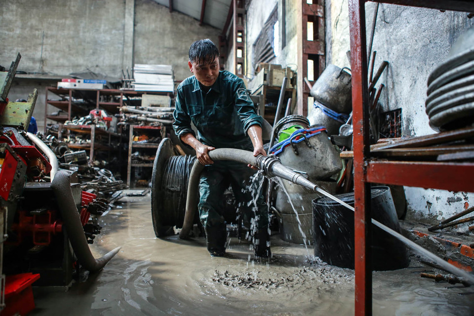 Vòi phun cao áp được huy động để gột rửa toàn bộ các thiết bị cơ khí. (Ảnh: Minh Sơn/Vietnam+)