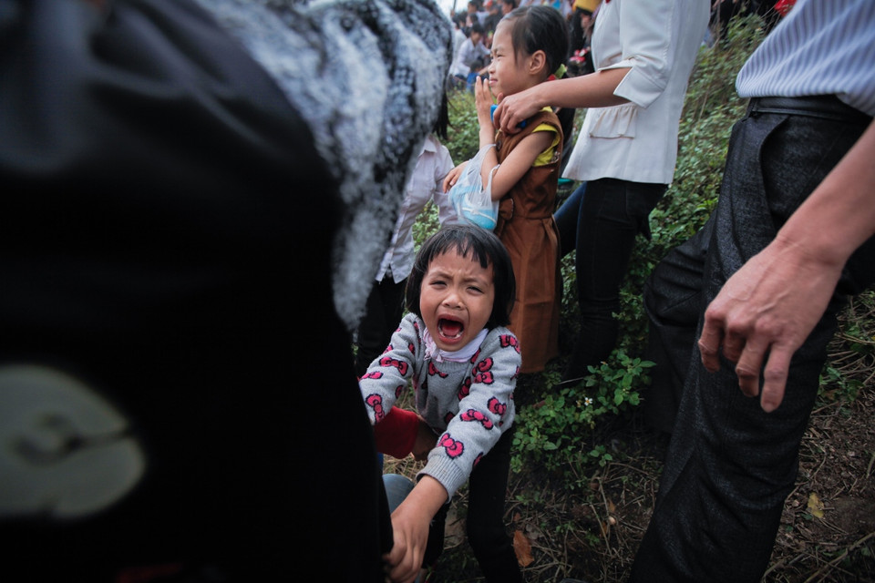Có bé gái đã bật khóc khi nhìn thấy cảnh tượng tranh cướp nhau kinh hoàng. (Ảnh: Thành Nguyễn/Vietnam+)