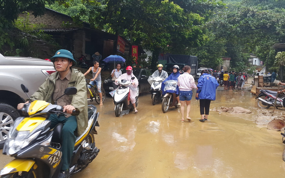 Nước lũ gây ngập lụt khiến giao thông của người dân gặp nhiều khó khăn. (Ảnh: Lục Thu Hương/TTXVN)