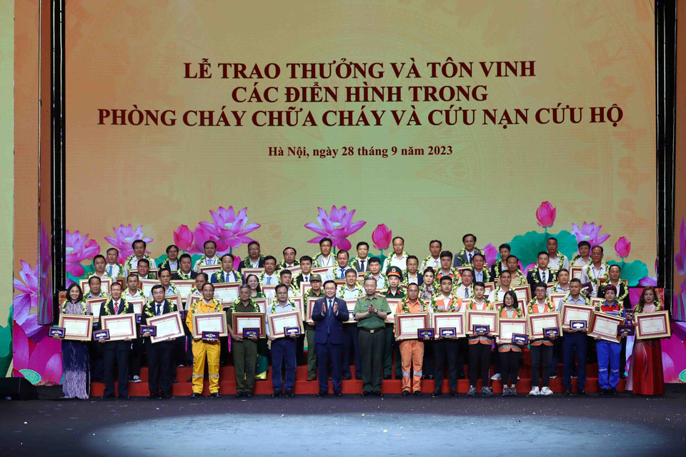 Chủ tịch Quốc hội Vương Đình Huệ và Đại tướng Tô Lâm, Bộ trưởng Bộ Công an tuyên dương các điển hình trong phong trào phòng cháy, chữa cháy và cứu nạn, cứu hộ. (Ảnh: Phạm Kiên/TTXVN)