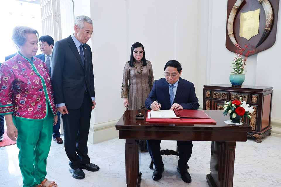 Thủ tướng Phạm Minh Chính ký sổ lưu niệm. (Ảnh: Dương Giang/TTXVN)