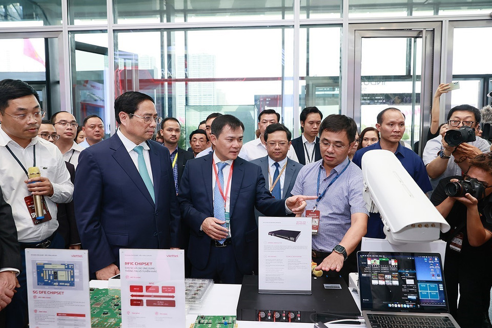 Thủ tướng Phạm Minh Chính nghe giới thiệu về một số sản phẩm công nghệ. (Ảnh: Dương Giang/TTXVN)