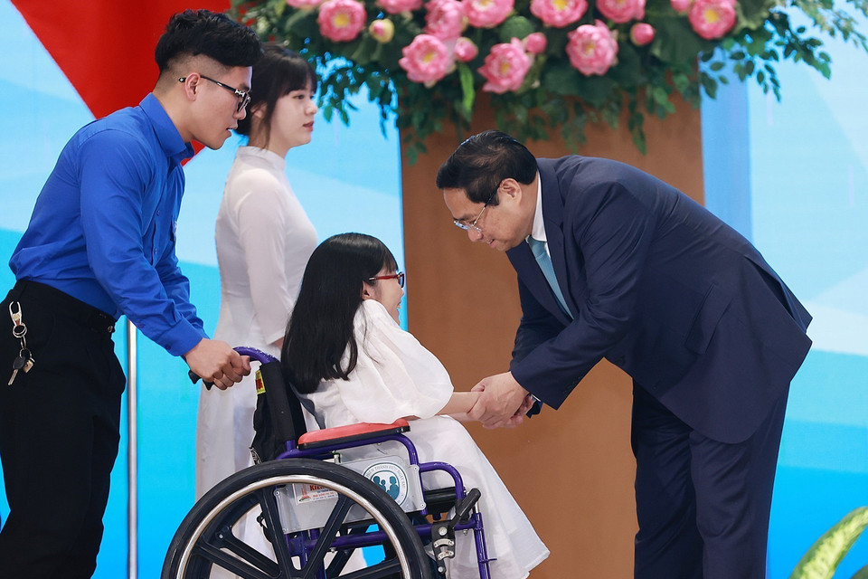 Thủ tướng Phạm Minh Chính với đại diện thanh niên có hoàn cảnh đặc biệt. (Ảnh: Dương Giang/TTXVN)