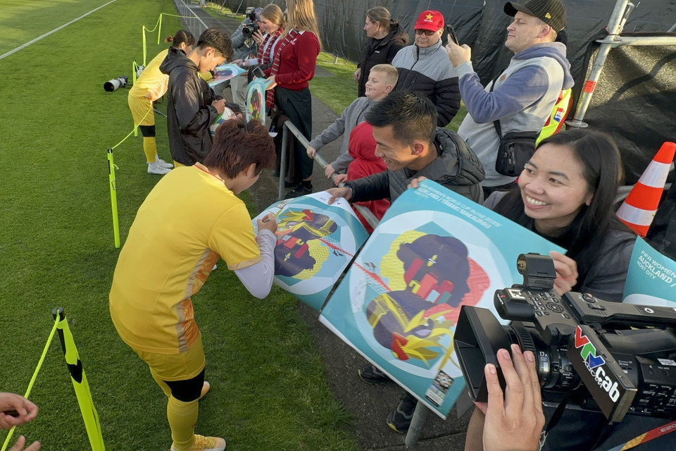 Cầu thủ Tuyển Bóng đá Nữ Việt Nam ký tên tặng người hâm mộ. (Ảnh: Trương Anh Ngọc/TTXVN)