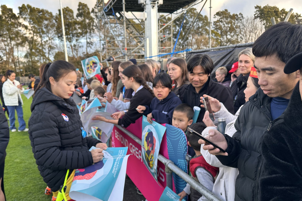 Cầu thủ Hoàng Thị Loan ký tên tặng người hâm mộ. (Ảnh: Trương Anh Ngọc/TTXVN)