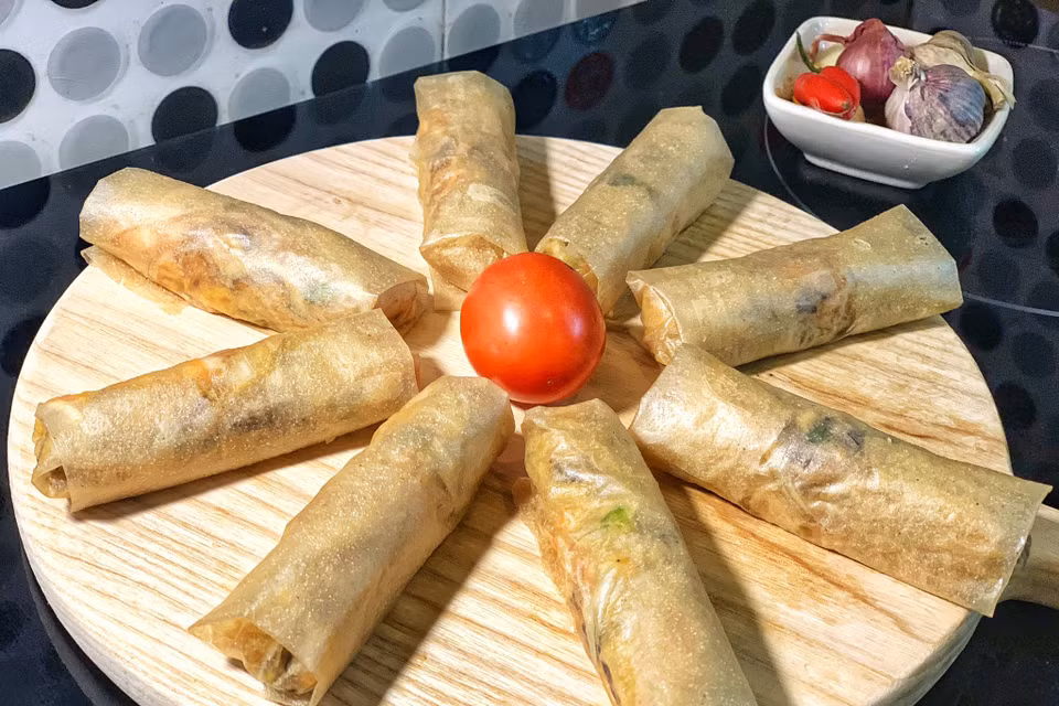 Nem cuốn đều tay, không quá chặt để không bị vỡ khi rán. (Ảnh: Mai Mai/Vietnam+)