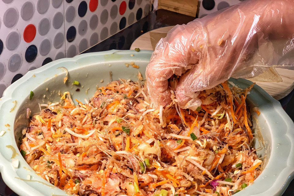 Trộn đều cùng hạt nêm, chút tiêu ướp trong khoảng 10 phút. Lưu ý chỉ trộn với lòng đỏ trứng gà, bỏ lòng trắng để hỗ hợp không bị chảy nước ướt bánh đa nem. (Ảnh: Mai Mai/Vietnam+)