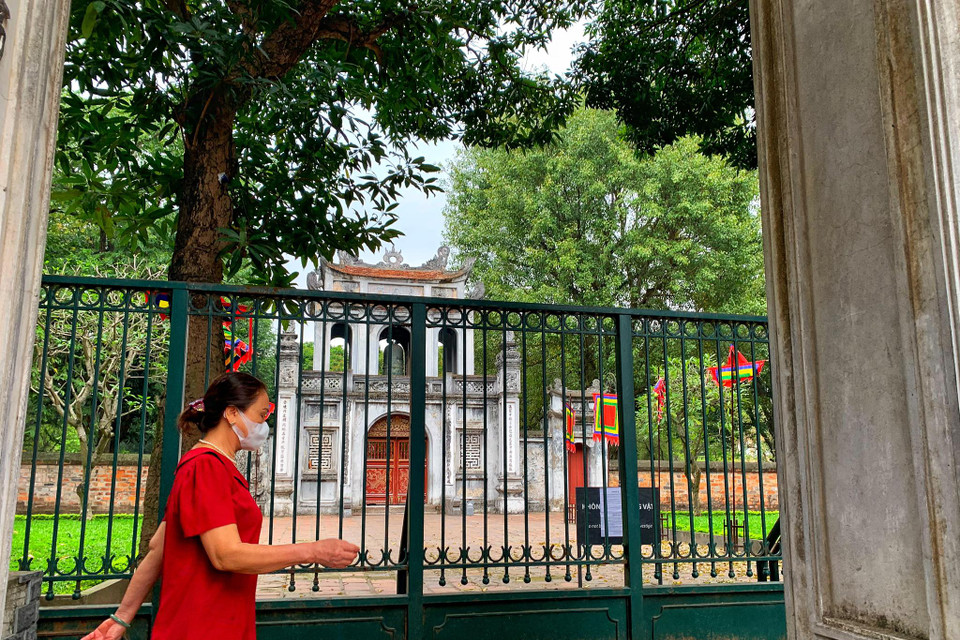 Những người dân thường ngày vẫn có thể đi bộ thể dục xung quanh khu vườn của Văn Miếu thì nay di tích đóng cửa, không còn lối vào. (Ảnh: Mai Mai/Vietnam+)