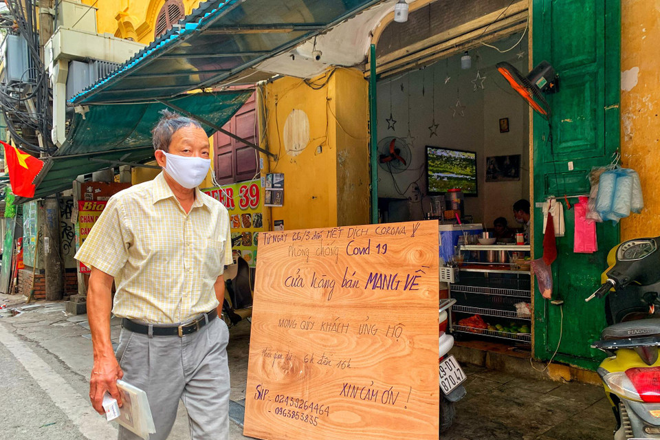 Trên những khu phố cổ vốn đông đúc hàng quán, tấp nập du khách nay chỉ còn lác đác quán phục vụ với thông báo không nhận khách tại chỗ, chỉ 'bán mang về' như thế này. (Ảnh: Mai Mai/Vietnam+)