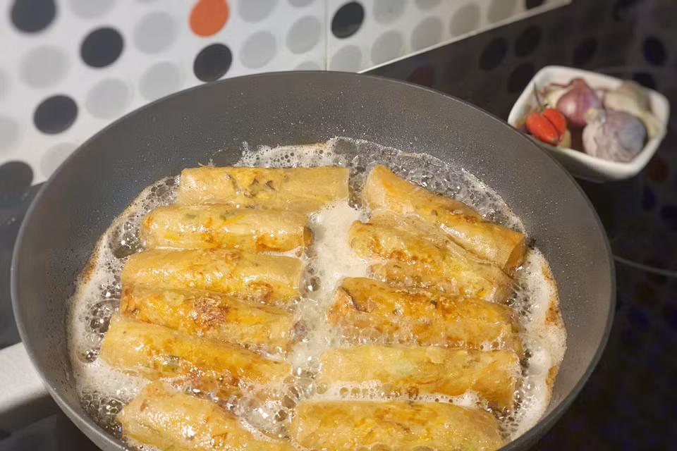 Cho dầu ăn vào chảo và rán nem vàng từng mặt. Với loại vỏ bánh đa nem này nem rán xong có thể giữ được lớp vỏ giòn rụm trong khoảng 1 tiếng. (Ảnh: Mai Mai/Vietnam+)