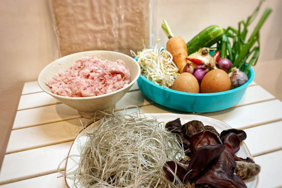Nguyên liệu: 300gr thịt băm, 1 củ hành tây, 1 củ tỏi, 2 quả ớt, 25-30 lá bánh đa nem, 5-10 cây nấm hương, 3 cây mộc nhĩ, 50gr miến rong, 100gr cà rốt, 3 quả trứng gà, 3-5 củ hành khô, hành hoa, 100gr giá. Gia vị pha: hạt tiêu, mắm, đường, hạt nêm, giấm, đường.(Ảnh: Mai Mai/Vietnam+)