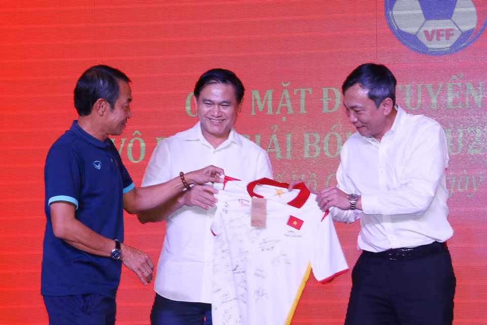 Huấn luyện viên đội U23 Việt Nam Đinh Thế Nam trao tặng chiếc áo có chữ ký của các tuyển thủ U23 Việt Nam, nhà vô địch Giải U23 Đông Nam Á 2022 cho lãnh đạo Liên đoàn bóng đá Việt Nam (Ảnh: Thanh Vũ/TTXVN)