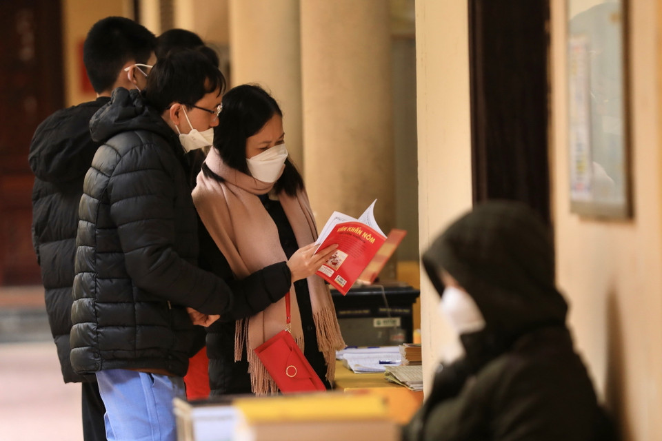 Người dân xem sách khi đến lễ tại chùa Quán Sứ sáng 13/2.(Ảnh: Hoàng Hiếu/TTXVN)