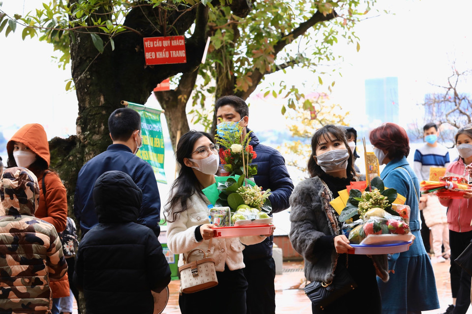 Nhiều người thành tâm chuẩn bị lễ vật khi vào lễ tại Phủ Tây Hồ (ảnh chụp ngày 13/2/2022 tức 13 tháng Giêng năm Nhâm Dần). (Ảnh: Hoàng Hiếu/TTXVN)