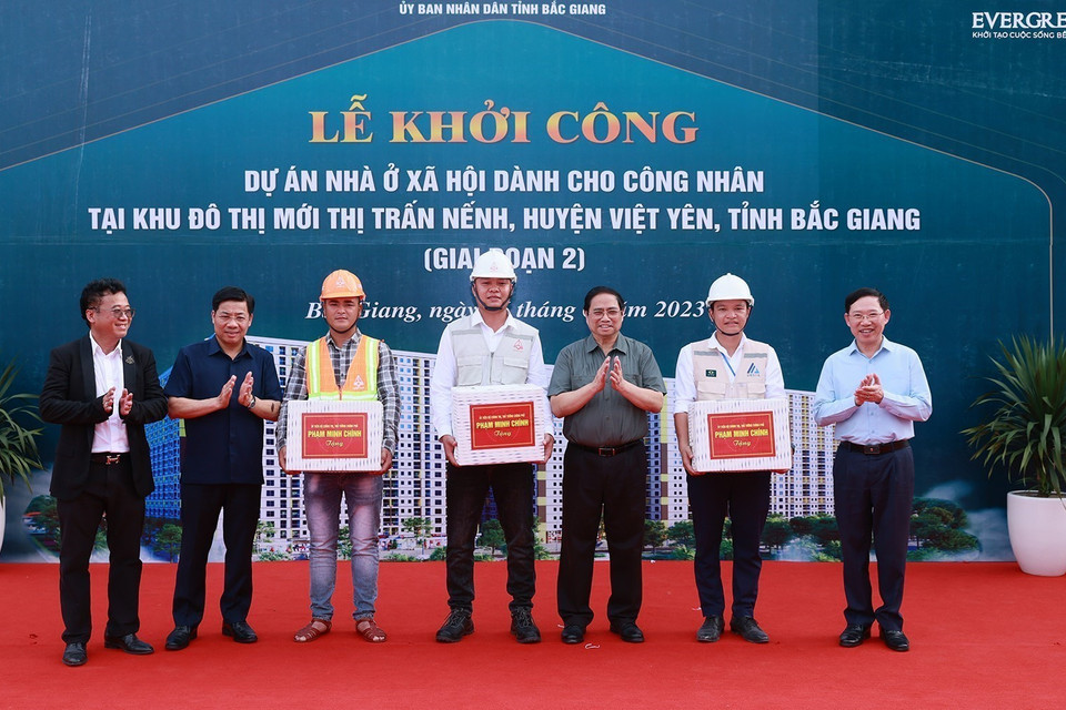 Thủ tướng Phạm Minh Chính tặng quà công nhân tham gia xây dựng dự án Nhà ở xã hội cho công nhân tại khu đô thị Nếnh. (Ảnh: Dương Giang/TTXVN)