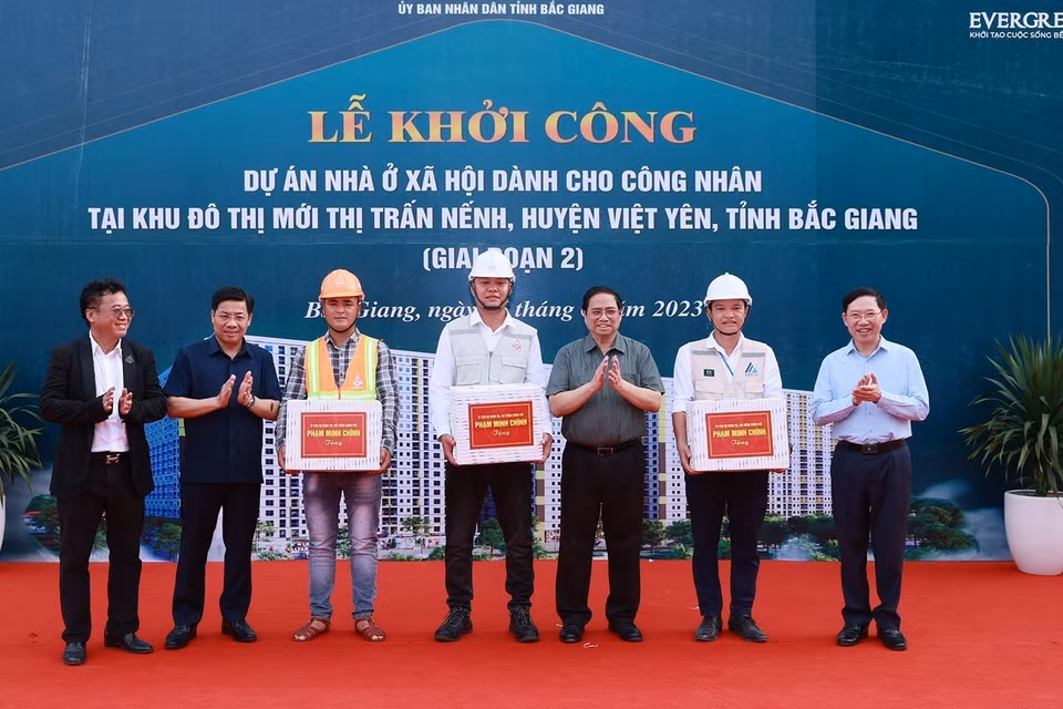 Thủ tướng Phạm Minh Chính tặng quà công nhân tham gia xây dựng dự án Nhà ở xã hội cho công nhân tại khu đô thị Nếnh. (Ảnh: Dương Giang/TTXVN)