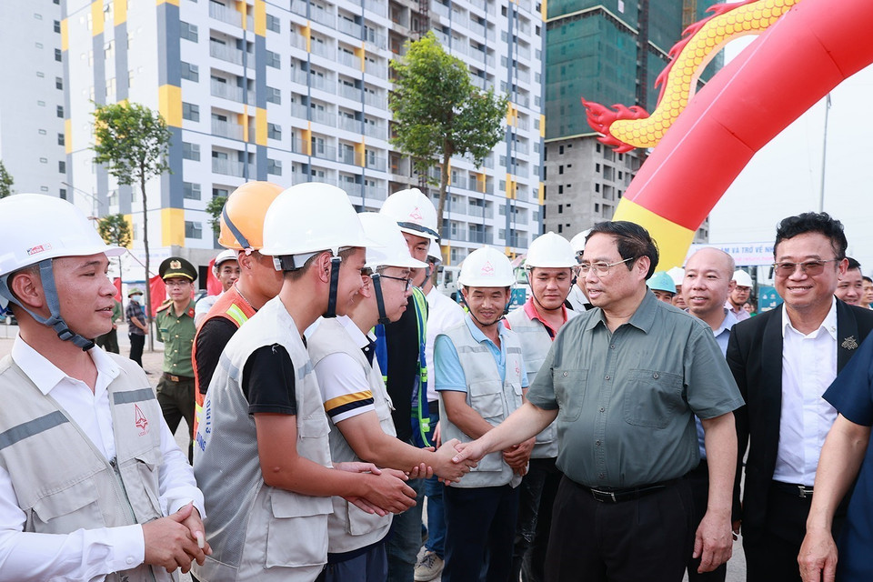 Thủ tướng Phạm Minh Chính với công nhân tham gia xây dựng dự án Nhà ở xã hội cho công nhân tại khu đô thị Nếnh. (Ảnh: Dương Giang/TTXVN)
