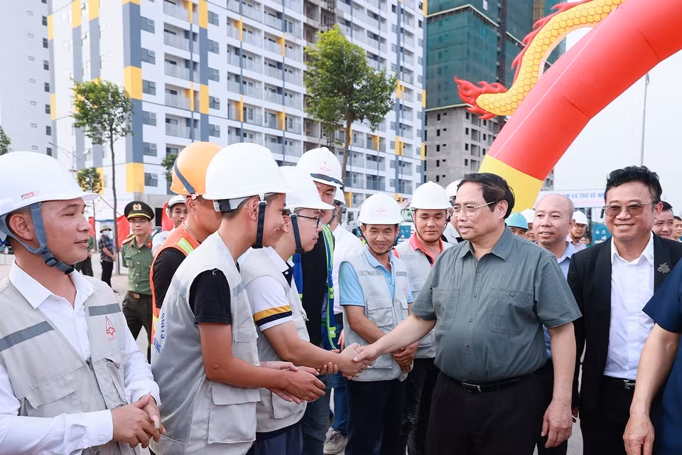 Thủ tướng Phạm Minh Chính với công nhân tham gia xây dựng dự án Nhà ở xã hội cho công nhân tại khu đô thị Nếnh. (Ảnh: Dương Giang/TTXVN)