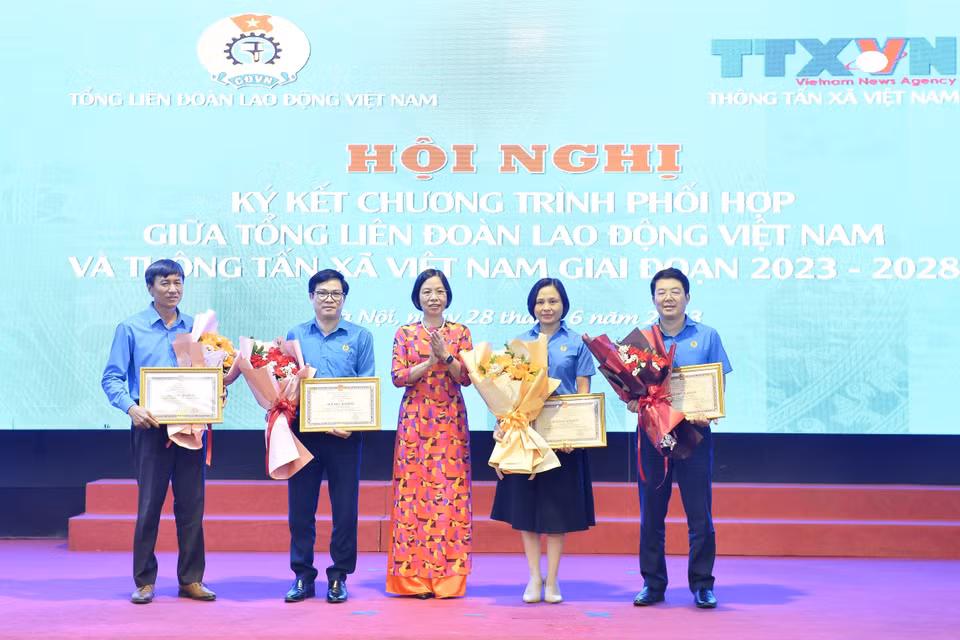 Tổng Giám đốc TTXVN Vũ Việt Trang trao tặng Bằng khen cho 1 tập thể và một số cá nhân của Tổng Liên đoàn Lao động Việt Nam. (Ảnh: Minh Đức/TTXVN) 