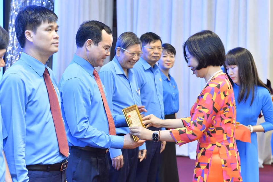 Tổng Giám đốc TTXVN Vũ Việt Trang trao tặng Kỷ niệm chương "Vì sự nghiệp Thông tấn xã Việt Nam" cho Chủ tịch Tổng Liên đoàn Lao động Việt Nam Nguyễn Đình Khang. (Ảnh: Minh Đức/TTXVN)