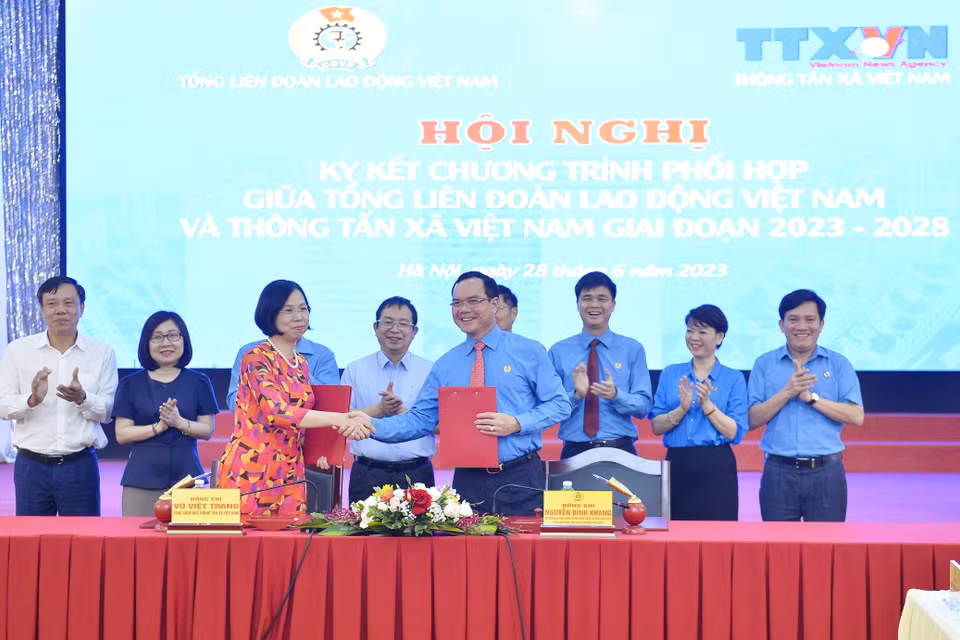Tổng Giám đốc TTXVN Vũ Việt Trang và Chủ tịch Tổng Liên đoàn Lao động Việt Nam Nguyễn Đình Khang ký kết văn kiện phối hợp tuyên truyền giai đoạn 2023-2028. (Ảnh: Minh Đức/TTXVN)