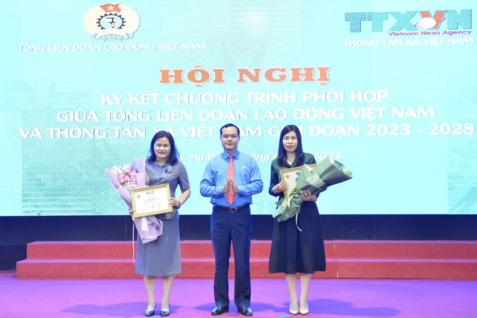 Chủ tịch Tổng Liên đoàn Lao động Việt Nam Nguyễn Đình Khang trao tặng Kỷ niệm chương "Vì sự nghiệp xây dựng tổ chức Công đoàn" cho 2 cán bộ của Thông tấn xã Việt Nam. (Ảnh: Minh Đức/TTXVN)