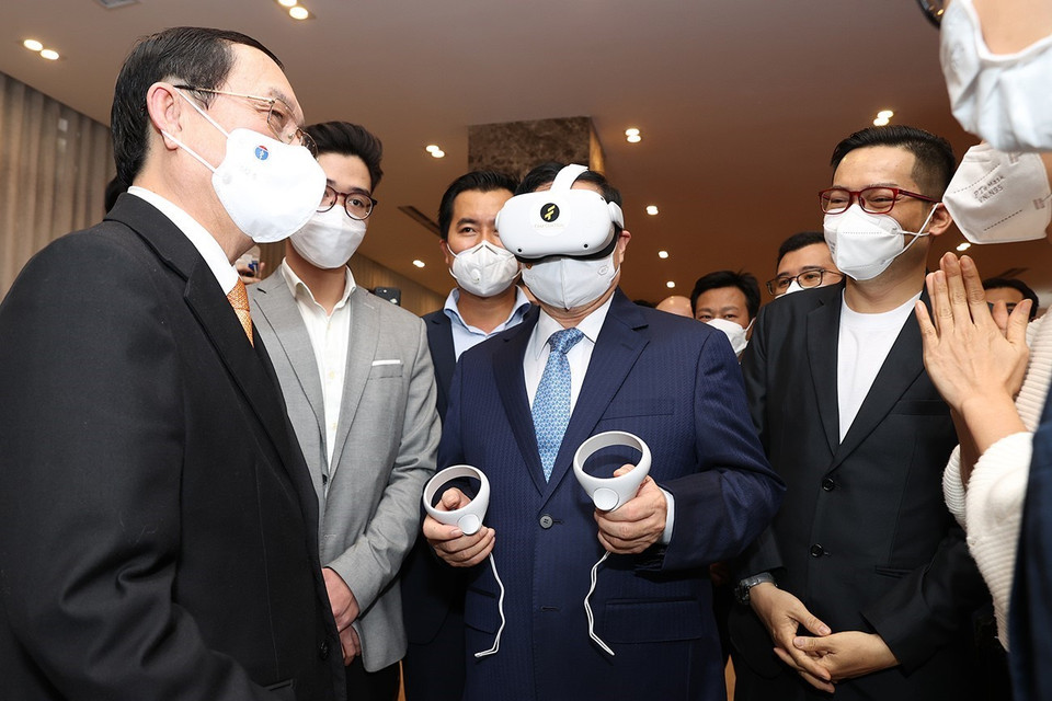 Thủ tướng Phạm Minh Chính trải nghiệm sản phẩm ứng dụng sáng tạo. (Ảnh: Dương Giang/TTXVN)