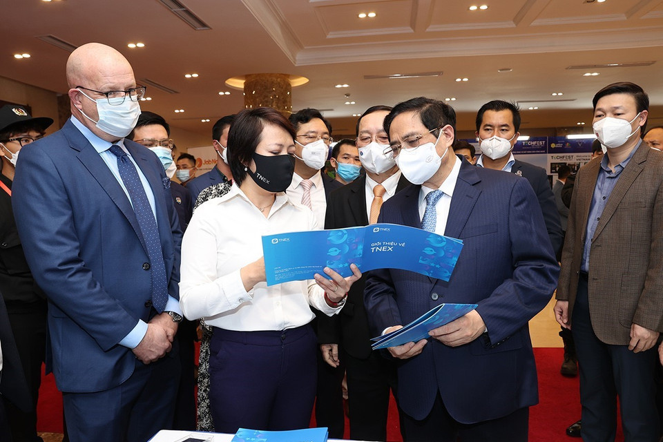 Thủ tướng Phạm Minh Chính và các đại biểu tham quan trưng bày các sản phẩm ứng dụng công nghệ sáng tạo. (Ảnh: Dương Giang/TTXVN)