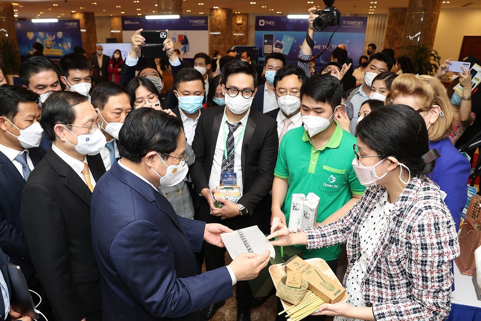 Thủ tướng Phạm Minh Chính và các đại biểu tham quan trưng bày các sản phẩm ứng dụng công nghệ sáng tạo. (Ảnh: Dương Giang/TTXVN)