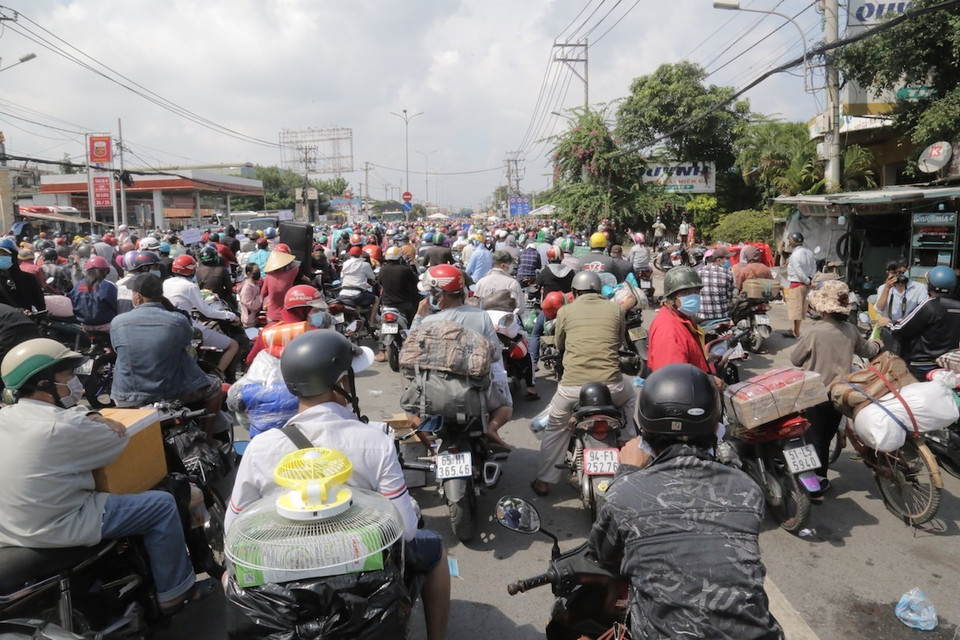 Hàng nghìn người dân tập trung ở khu vực Quốc lộ 1 đoạn qua Thị trấn Tân Túc, huyện Bình Chánh, Thành phố Hồ Chí Minh để chờ đợi về quê . (Ảnh: TTXVN phát)