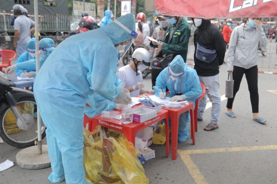 Tổ chức test nhanh COVID-19 cho người dân trước khi qua chốt kiểm soát để về quê tại khu vực Thị trấn Tân Túc, huyện Bình Chánh, Thành phố Hồ Chí Minh. (Ảnh: TTXVN phát)