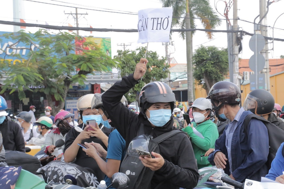 Hàng nghìn người dân tập trung ở khu vực Quốc lộ 1 đoạn qua Thị trấn Tân Túc, huyện Bình Chánh, Thành phố Hồ Chí Minh để chờ đợi về quê . (Ảnh: TTXVN phát)