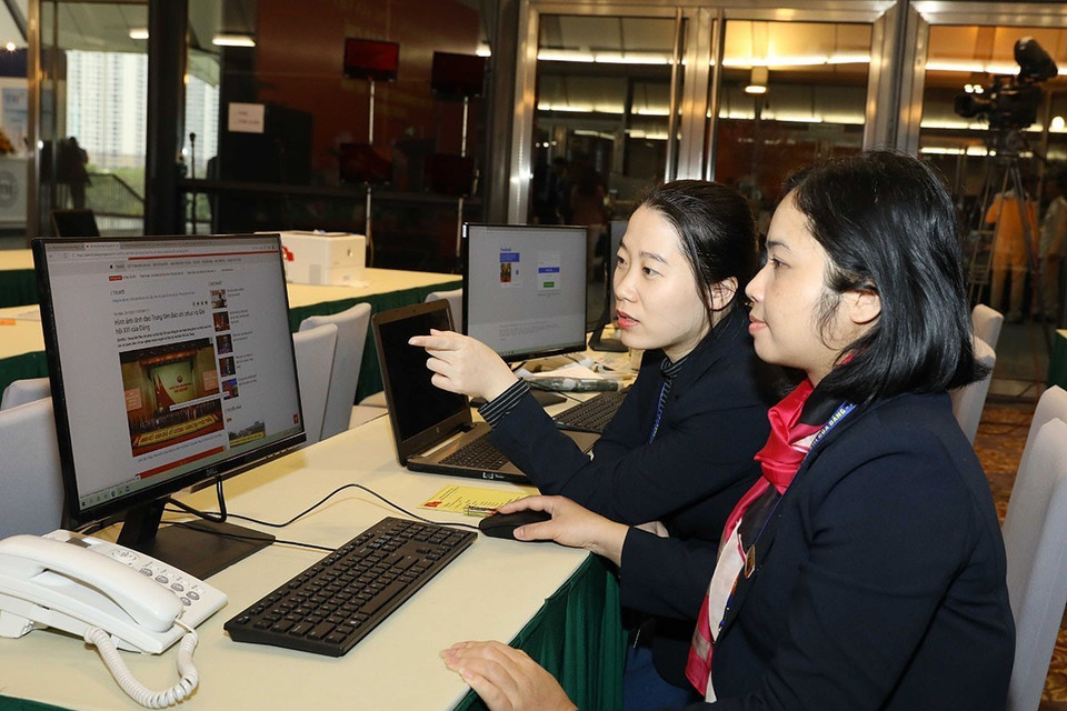 Các biên tập viên Ban biên tập tin Đối ngoại TTXVN làm việc tại Trung tâm báo chí Đại hội XIII của Đảng. (Ảnh: TTXVN)