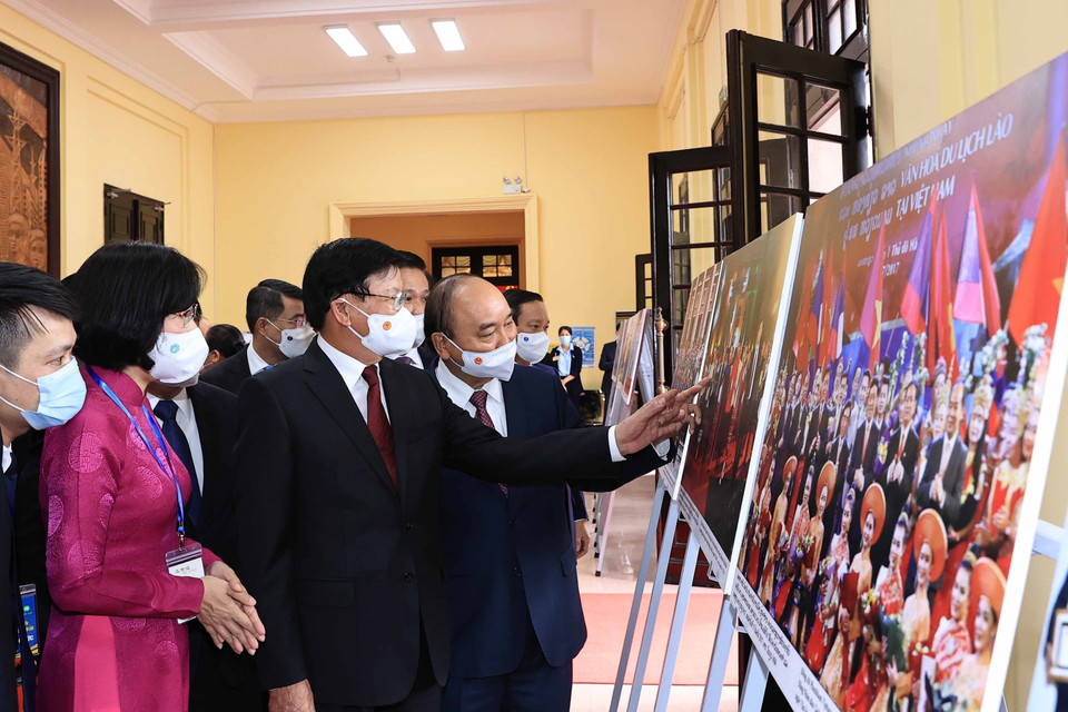 Phó Tổng Giám đốc Vũ Việt Trang giới thiệu trưng bày ảnh Quan hệ hữu nghị vĩ đại, đoàn kết đặc biệt và hợp tác toàn diện Việt Nam-Lào của TTXVN với Tổng Bí thư, Chủ tịch nước Lào Thongloun Sisoulith và Chủ tịch nước Nguyễn Xuân Phúc. (Ảnh: Thống Nhất/TTXVN)