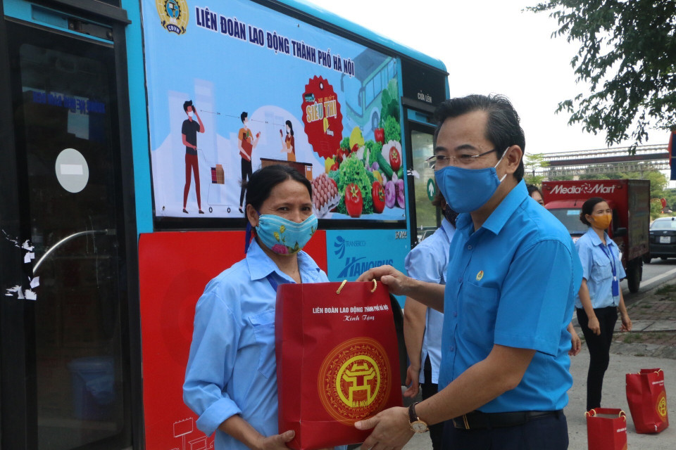 Công nhân Xí nghiệp Mây tre Ngọc Sơn (thị trấn Chúc Sơn, huyện Chương Mỹ) nhận quà hỗ trợ khó khăn từ tổ chức Công đoàn Thủ đô. (Ảnh: TTXVN phát)