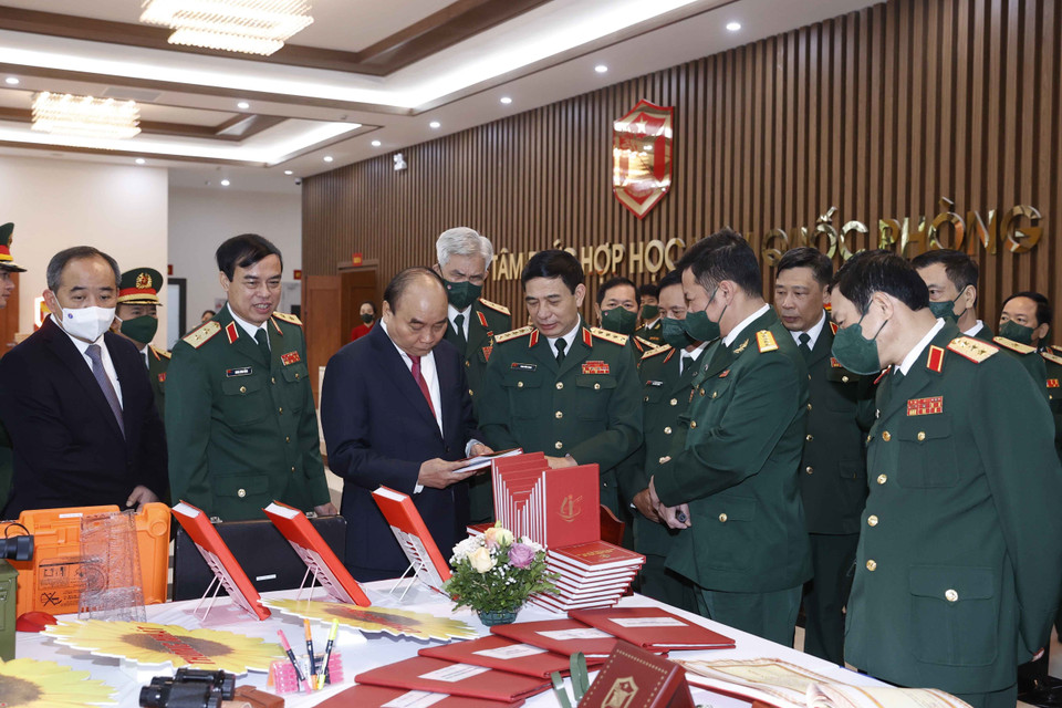 Chủ tịch nước Nguyễn Xuân Phúc và các đại biểu tham quan gian trưng bày các ấn phẩm của Học viện Quốc phòng. (Ảnh: Thống Nhất/TTXVN)