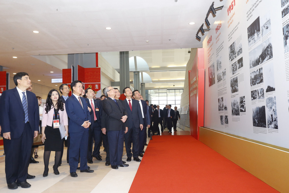 Thường trực Ban Bí thư Trần Quốc Vượng, Trưởng Ban Tuyên giáo Trung ương Võ Văn Thưởng và đại biểu tham quan Trưng bày ảnh Vững bước dưới cờ Đảng quang vinh do Ban Tuyên giáo Trung ương và Thông tấn xã Việt Nam tổ chức. (Ảnh: TTXVN)