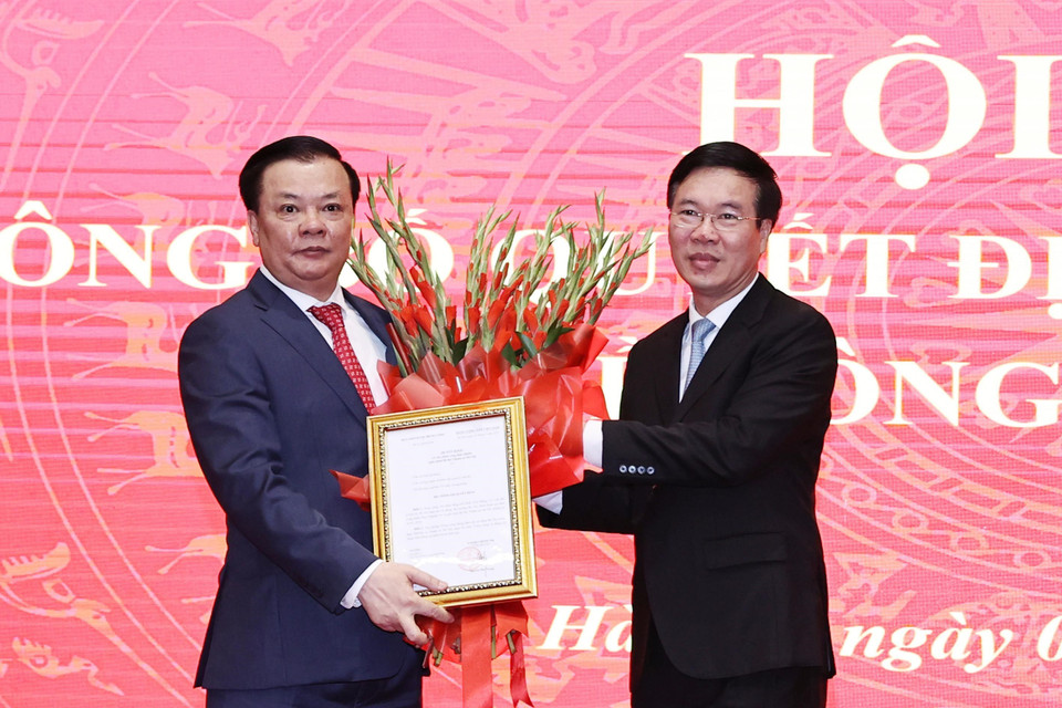 Ông Võ Văn Thưởng trao Quyết định của Bộ Chính trị phân công ông Đinh Tiến Dũng giữ chức Bí thư Thành ủy Hà Nội. (Ảnh: Trọng Đức/TTXVN)