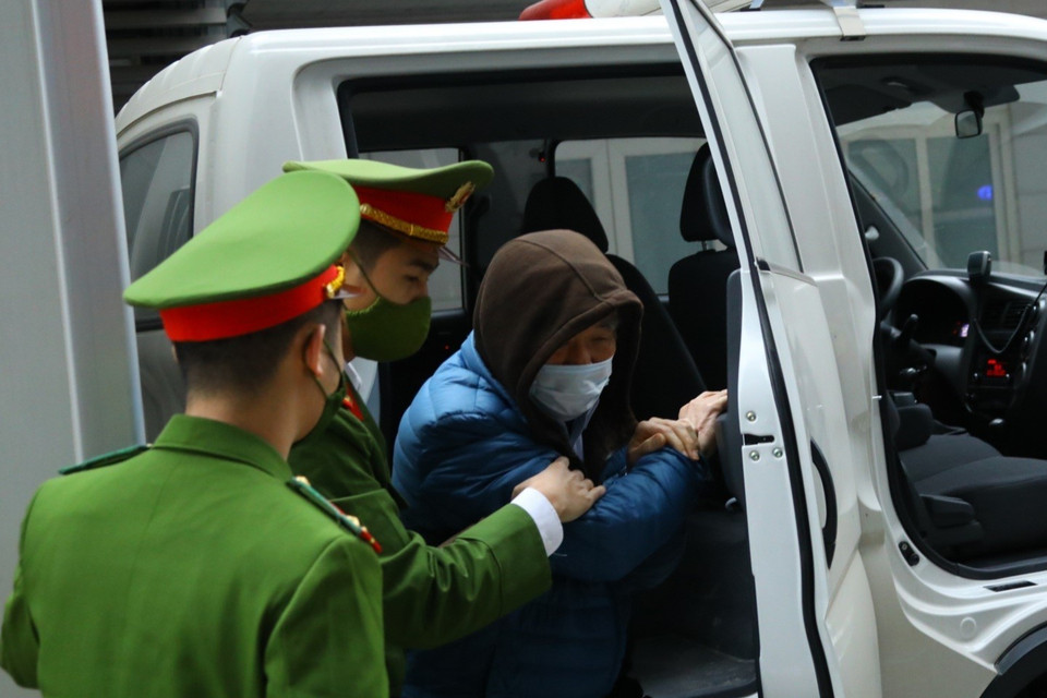 Hình ảnh cảnh sát dẫn giải các bị cáo đến tòa. (Ảnh: TTXVN)