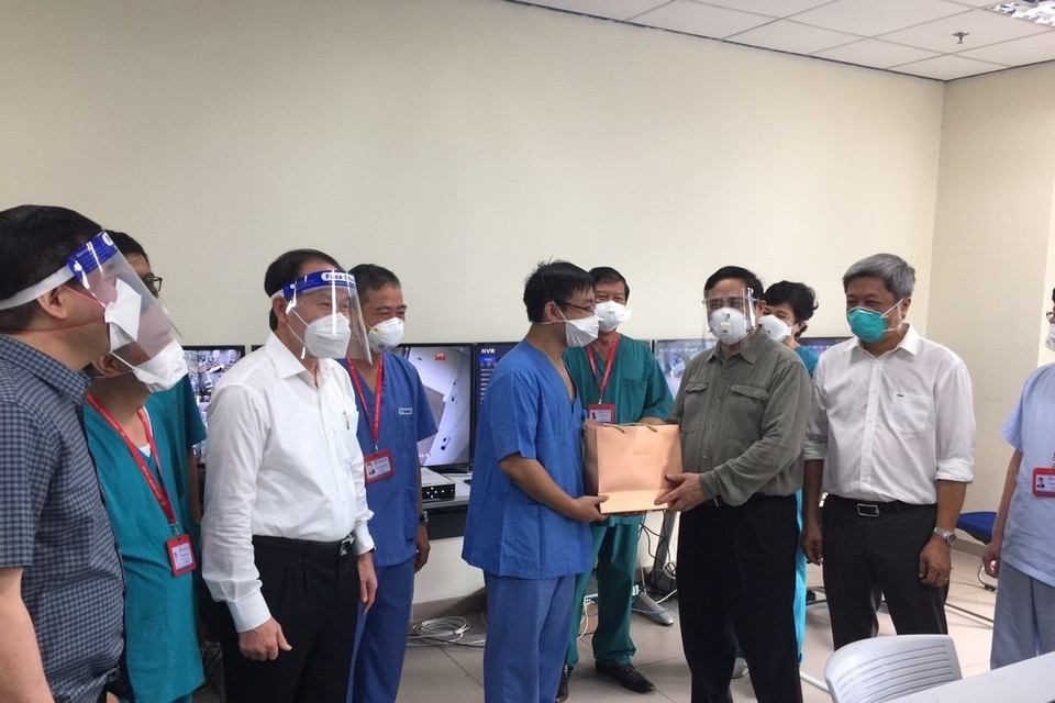 Thủ tướng Phạm Minh Chính tặng quà đội ngũ bác sỹ đang tham gia điều trị bệnh nhân COVID-19 tại bệnh viện dã chiến Hồi sức tích cực ở Bệnh viện quốc tế Becamex tỉnh Bình Dương. (Ảnh: TTXVN)