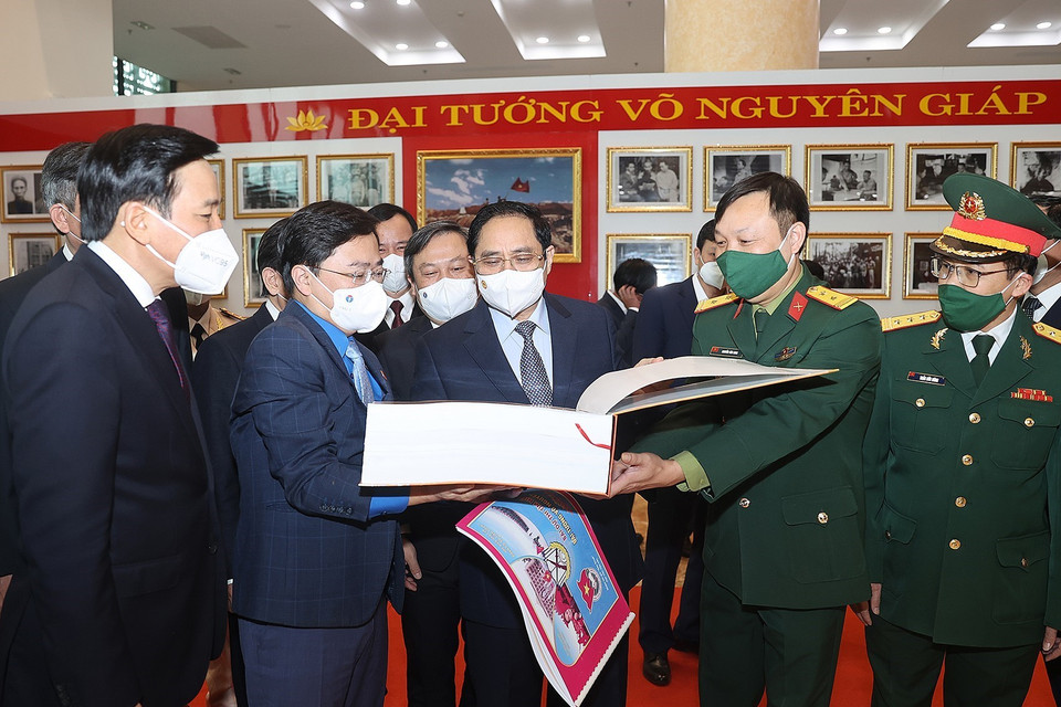 Thủ tướng Phạm Minh Chính và các đại biểu tham quan trưng bày ảnh và tư liệu, bài thi tìm hiểu về cuộc đời và sự nghiệp của Đại tướng Võ Nguyên Giáp. (Ảnh: Dương Giang/TTXVN)