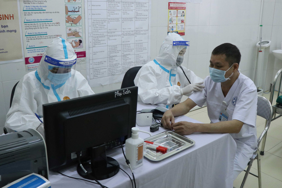 Khám sàng lọc trước khi tiêm vaccine phòng COVID-19. (Ảnh: Xuân Tiến/TTXVN)