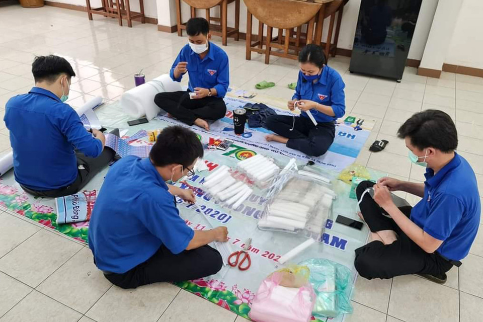 Đoàn viên thanh niên Tỉnh đoàn Tiền Giang làm mũ bảo hộ để tặng các điểm cách ly và các chốt kiểm dịch. (Ảnh: Hữu Chí/TTXVN)