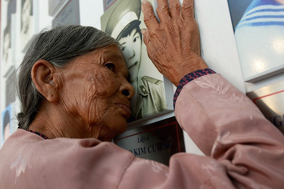 Bà Hà Thị Liên (quê ở huyện Can Lộc, tỉnh Hà Tĩnh), mẹ liệt sỹ Đào Kim Cương, trước di ảnh con trai ở khu lưu niệm di vật liệt sỹ Gạc Ma trong Khu tưởng niệm chiến sỹ Gạc Ma (Khánh Hòa). (Ảnh: TTXVN phát) 