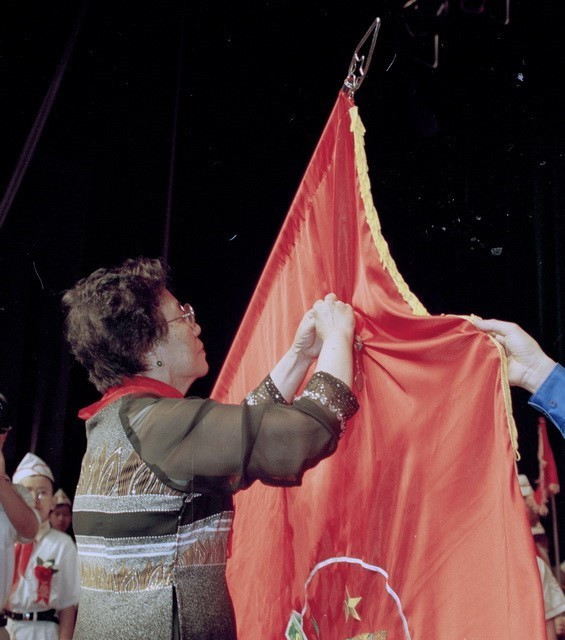 Phó Chủ tịch nước Nguyễn Thị Bình gắn Huân chương Sao vàng lên lá cờ truyền thống của Đội Thiếu niên Tiền phong Hồ Chí Minh (2001). (Ảnh: Đình Trân/TTXVN)