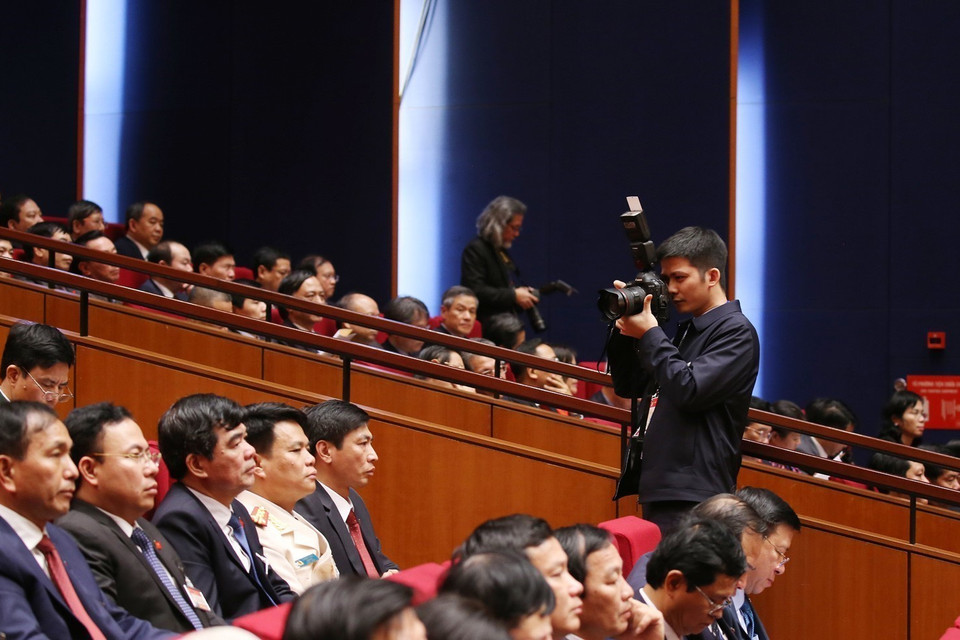 Phóng viên Ban Biên tập Ảnh TTXVN tác nghiệp tại phiên khai mạc Đại hội XIII của Đảng. (Ảnh: TTXVN)