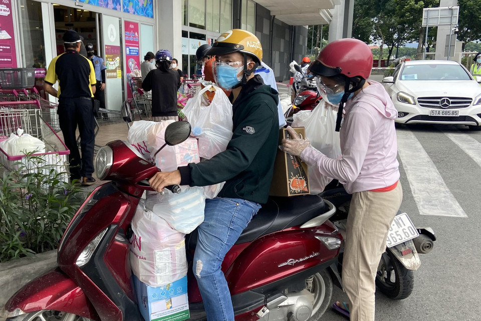 Xe máy người dân chất đầy thực phẩm sau khi mua từ Trung tâm thương mại Aeon Mall Tân Phú. (Ảnh: Mạnh Linh/TTXVN)