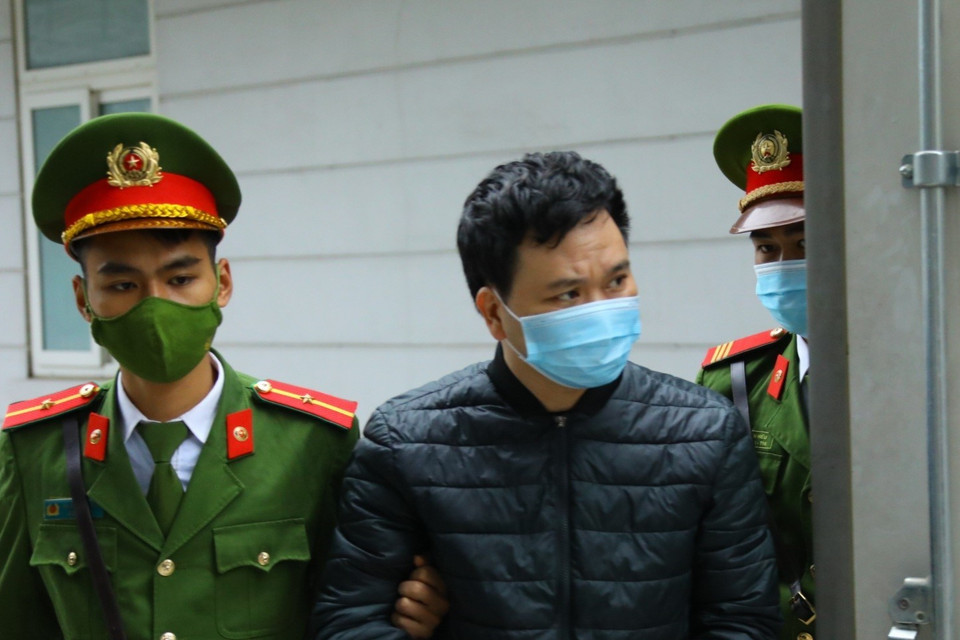 Cảnh sát dẫn giải các bị cáo đến tòa. (Ảnh: TTXVN)