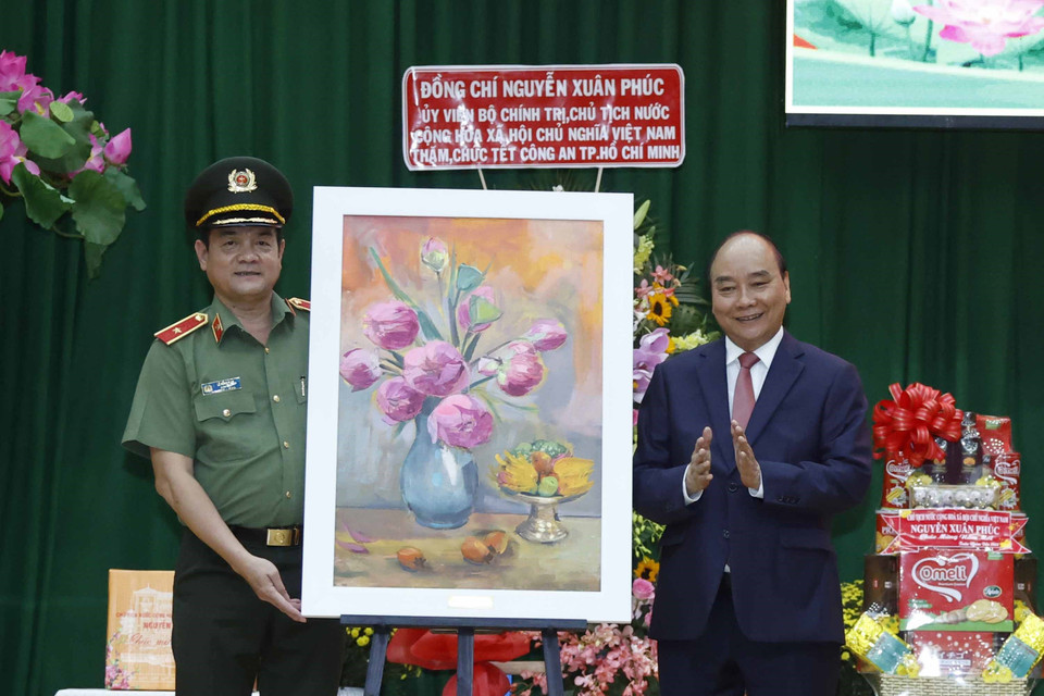 Chủ tịch nước Nguyễn Xuân Phúc tặng quà lưu niệm cho Công an Thành phố Hồ Chí Minh. (Ảnh: Thống Nhất/TTXVN)